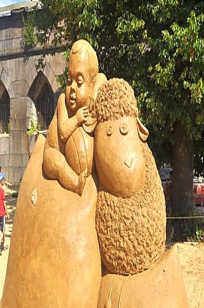 Sand Festival в России: скульптура мальчика и овцы из песка у арочного здания